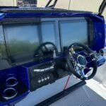 Offshore performance boat helm featuring dual Garmin navigation displays, carbon fiber dash, and stainless steering wheel